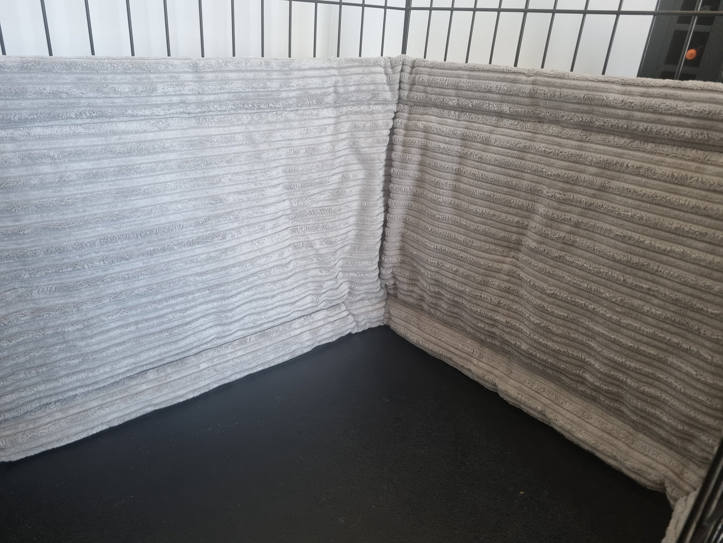 Close up. Dog crate bumper. Soft grey dog crate bumper pads attaching to metal dog crate to support with puppy training and dog training.