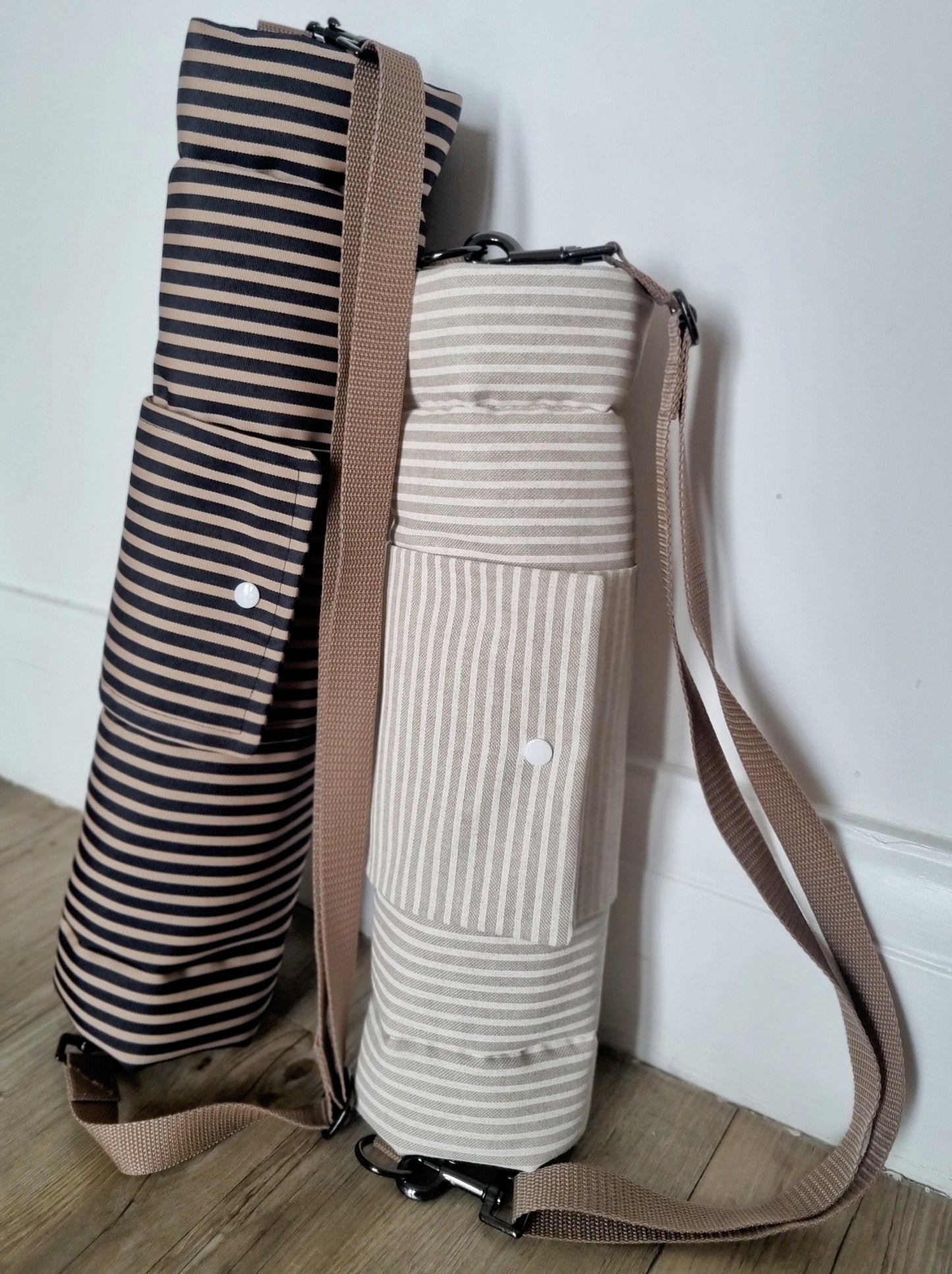 Neutral striped foldable dog settle mat with roll up fastening and strap to support with puppy settle training. This travel mat for dogs features a removable strap, a roll up fastening and a padded mat.