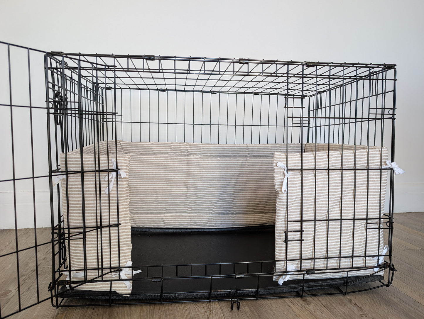 Dog crate bumper. Neutral striped dog crate bumper pads attaching to metal dog crate to support with puppy training and dog training.
