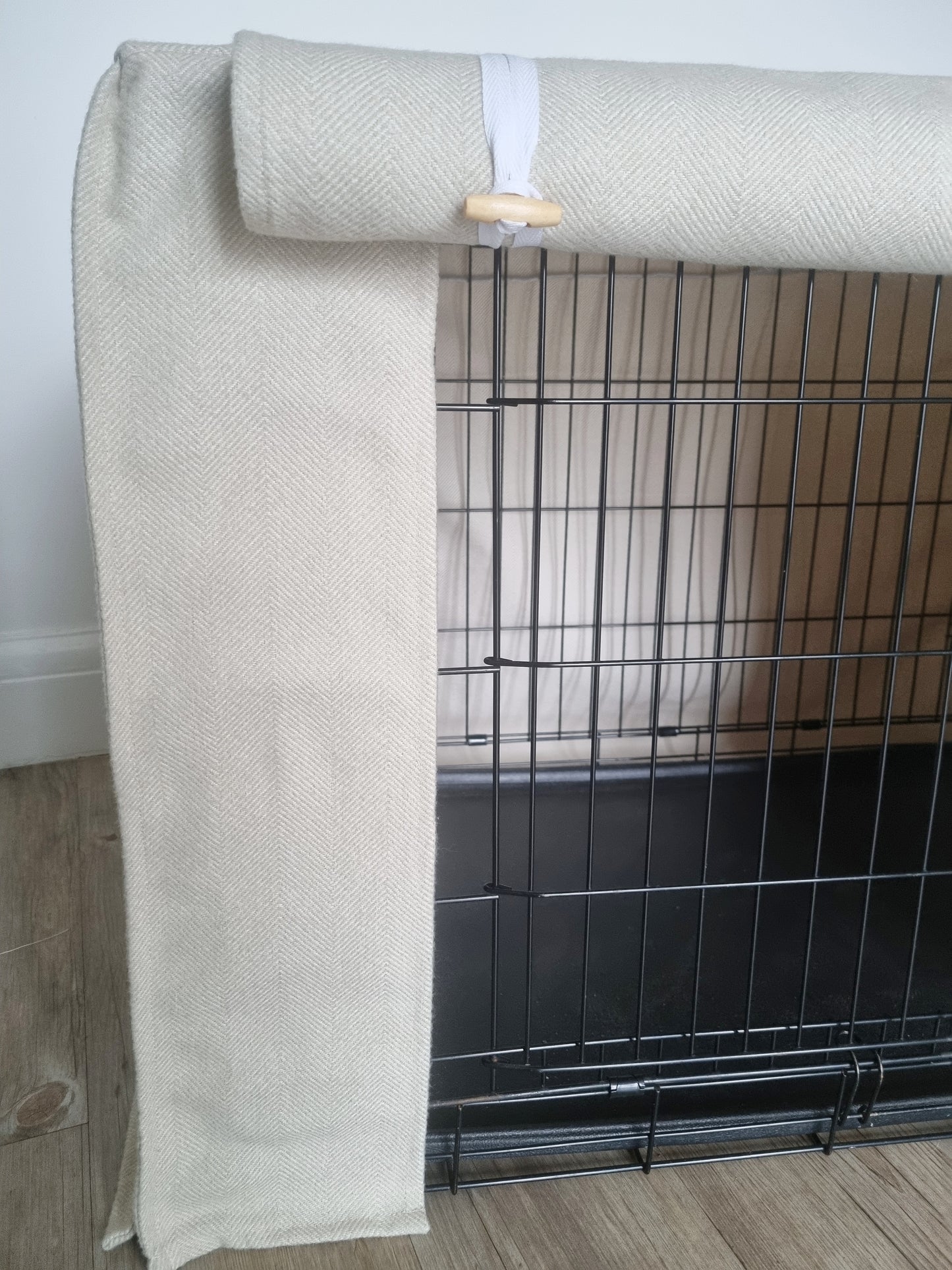 Stylish fabric dog crate cover. The custom kennel cover features a cream-toned, aesthetic design with a herringbone pattern, offering a cosy and decorative touch to the pet's space.