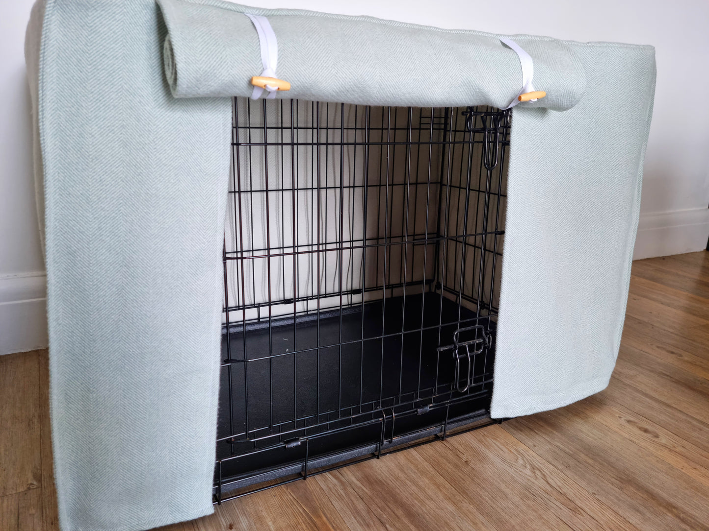 Stylish fabric dog crate cover. The custom kennel cover features a cream-toned, aesthetic design with a herringbone pattern, offering a cosy and decorative touch to the pet's space.