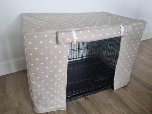 "A black wire dog crate covered with a custom fabric dog crate cover in a taupe spotty design. The aesthetic kennel cover features a minimalist design with a roll-up front panel.