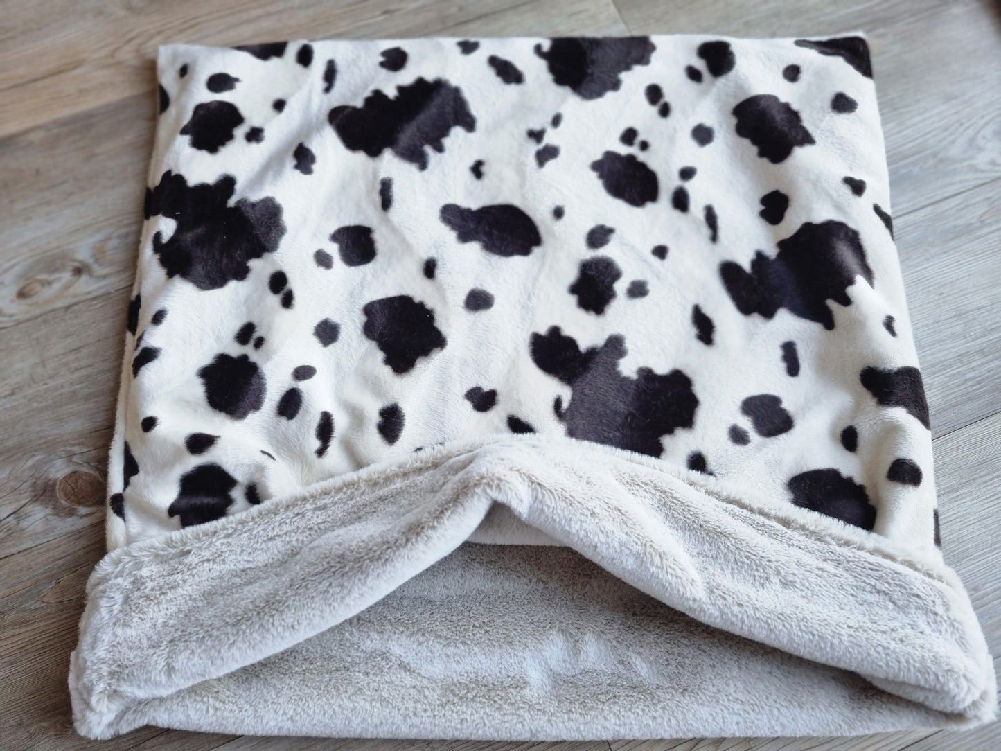 Cow print snuggle sack for dogs. This animal print snuggle den provides comfort and warmth to all dogs, cats, guinea pigs.