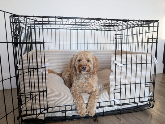 Dog crate bumper and bed - dog crate bedding. Neutral beige and white ticking striped dog crate bumper pads attaching to metal dog crate to support with puppy training and dog crate training. 