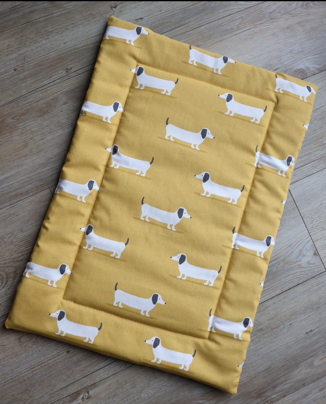 Mustard dachshund dog settle mat with roll up fastening to support with puppy settle training.